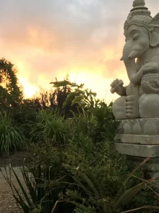 夕焼けに染まる自然と石像のシルエット