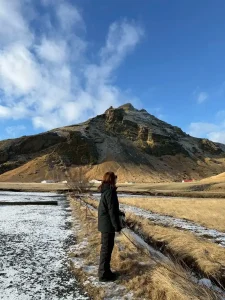 アイスランドの雄大な山と雪景色の前に立つ旅行者