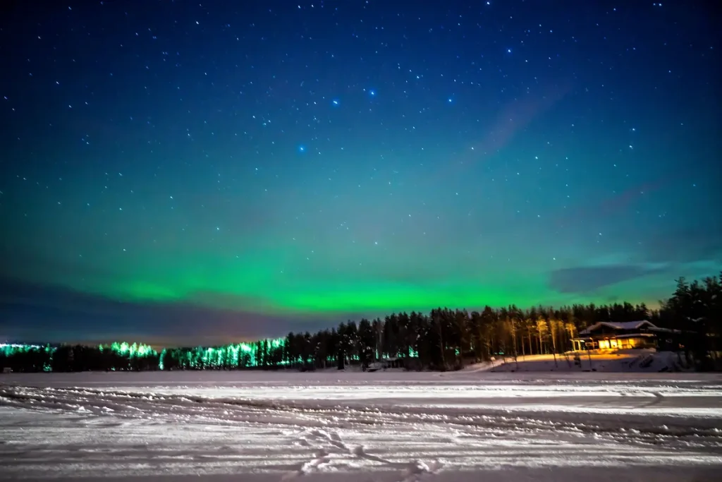 フィンランド・ロヴァニエミの夜空に広がるオーロラと雪景色