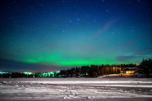 フィンランド・ロヴァニエミの夜空に広がるオーロラと雪景色