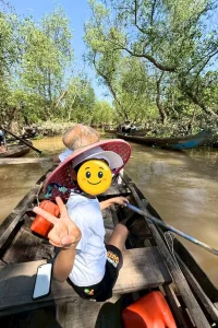 ベトナムの水辺を小舟で進む子ども連れの家族