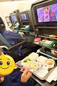 機内で食事を楽しむ子ども連れの家族旅行