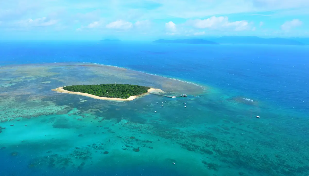 ケアンズ沖のグレートバリアリーフに浮かぶ小島とサンゴ礁の海を上空から撮影した風景