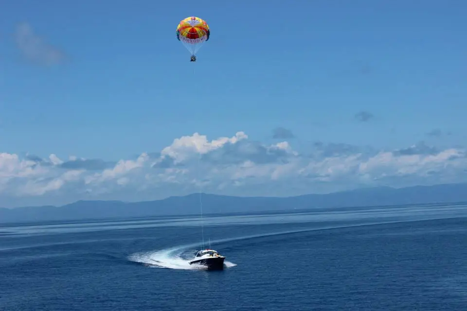 グリーン島周辺の海でパラセイリングを楽しむボートと青空