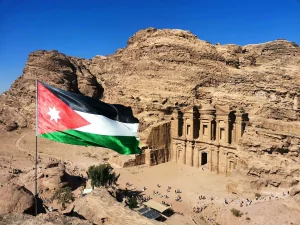 ヨルダン・ペトラ遺跡の岩山に刻まれた建造物と国旗