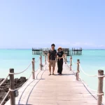 アフリカハネムーンで楽しめる青い海と桟橋に立つカップルのリゾート風景