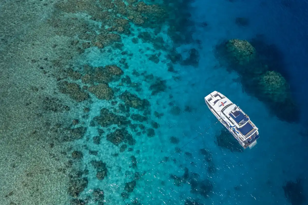 ケアンズ沖のグレートバリアリーフ上空から見た、青い海と船の絶景風景