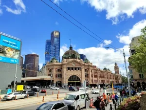 青空の下に建つメルボルンのフリンダース・ストリート駅と市街地の風景