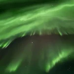 レイキャビック近郊で見られるアイスランドの夜空に広がる緑のオーロラ