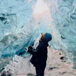 アイスランドの氷の洞窟で氷河観光を楽しむ旅行者