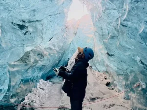 アイスランドの氷の洞窟で氷河観光を楽しむ旅行者