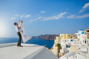 ヨーロッパ新婚旅行記事のサントリーニの青い海と白い街並みを背景にした新婚旅行のカップル