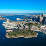 シドニー湾を上空から望み、オペラハウスとハーバーブリッジが見える港の風景