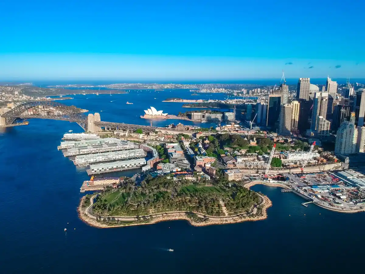 シドニー湾を上空から望み、オペラハウスとハーバーブリッジが見える港の風景