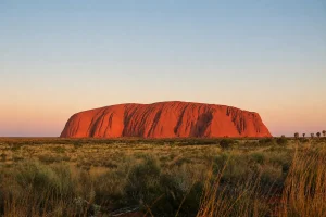 ウルル（エアーズロック）を中央に望むオーストラリア内陸部の赤い大地と草原風景