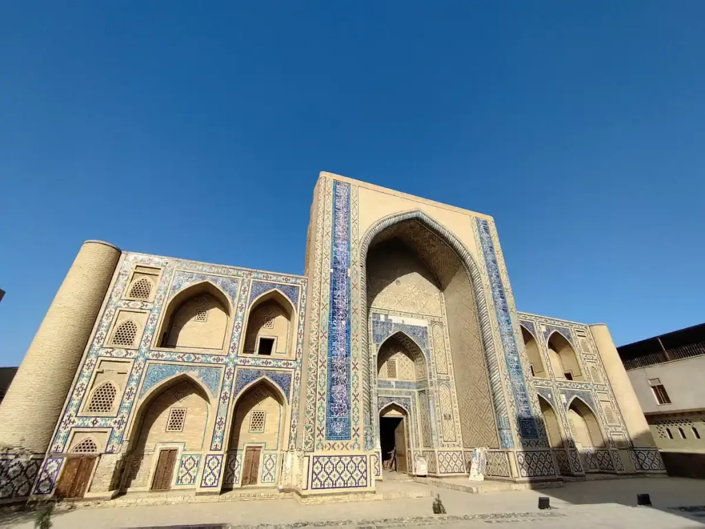青空の下に立つウズベキスタンの青いタイル装飾が美しい歴史建築