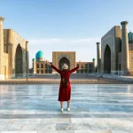サマルカンドのレギスタン広場を訪れる旅行者と青いタイル建築
