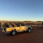 ナミビアの砂漠地帯に停車するオープンタイプの4WDサファリ車