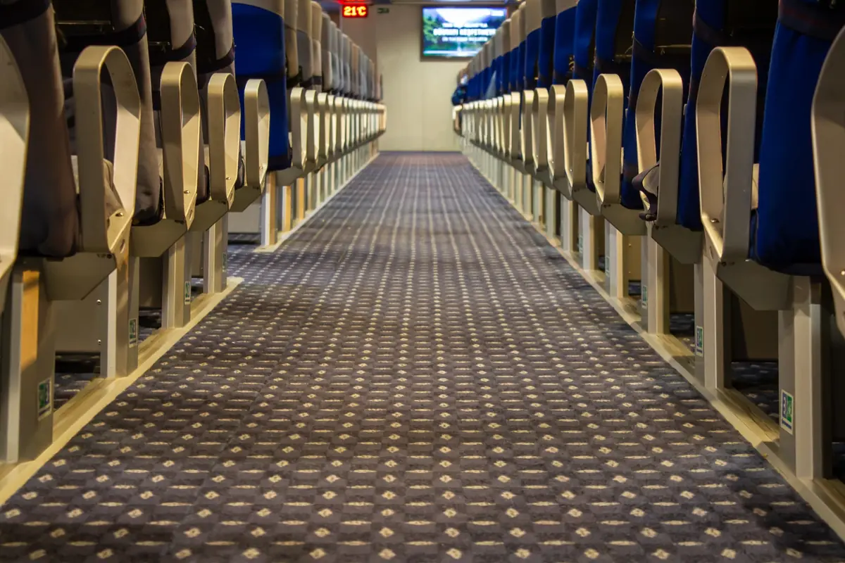 中央通路の両側に青い座席が規則的に並ぶ、グリーン島行きフェリーの広い船内客席