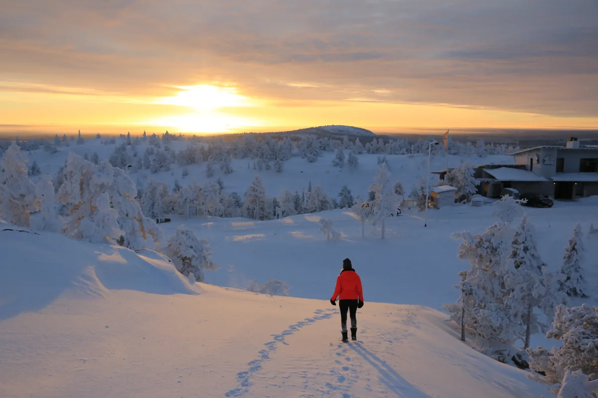 雪原を歩く人物と冬の夕景