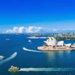 シドニー湾に浮かぶ船とオペラハウスを望む青空のハーバー風景