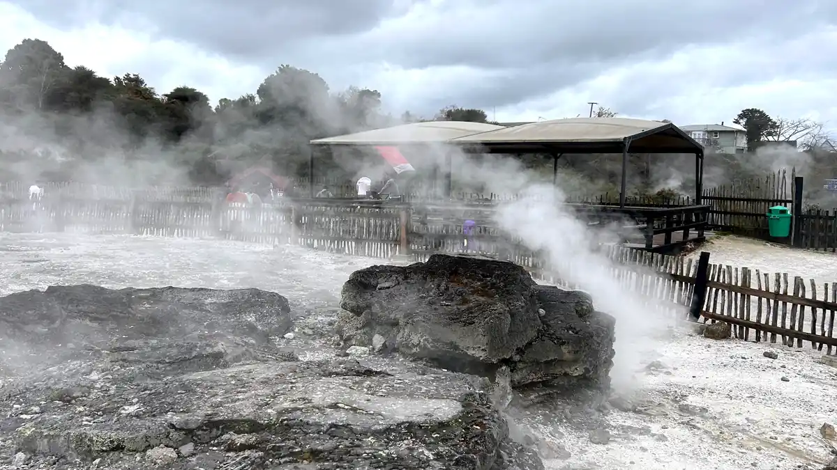 ロトルアの岩場から白い蒸気が立ち上る地熱地帯
